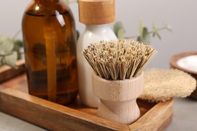 Photo of Cleaning brush, bottles and sponge on table, closeup