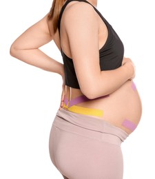 Sporty pregnant woman with kinesio tapes on white background, closeup