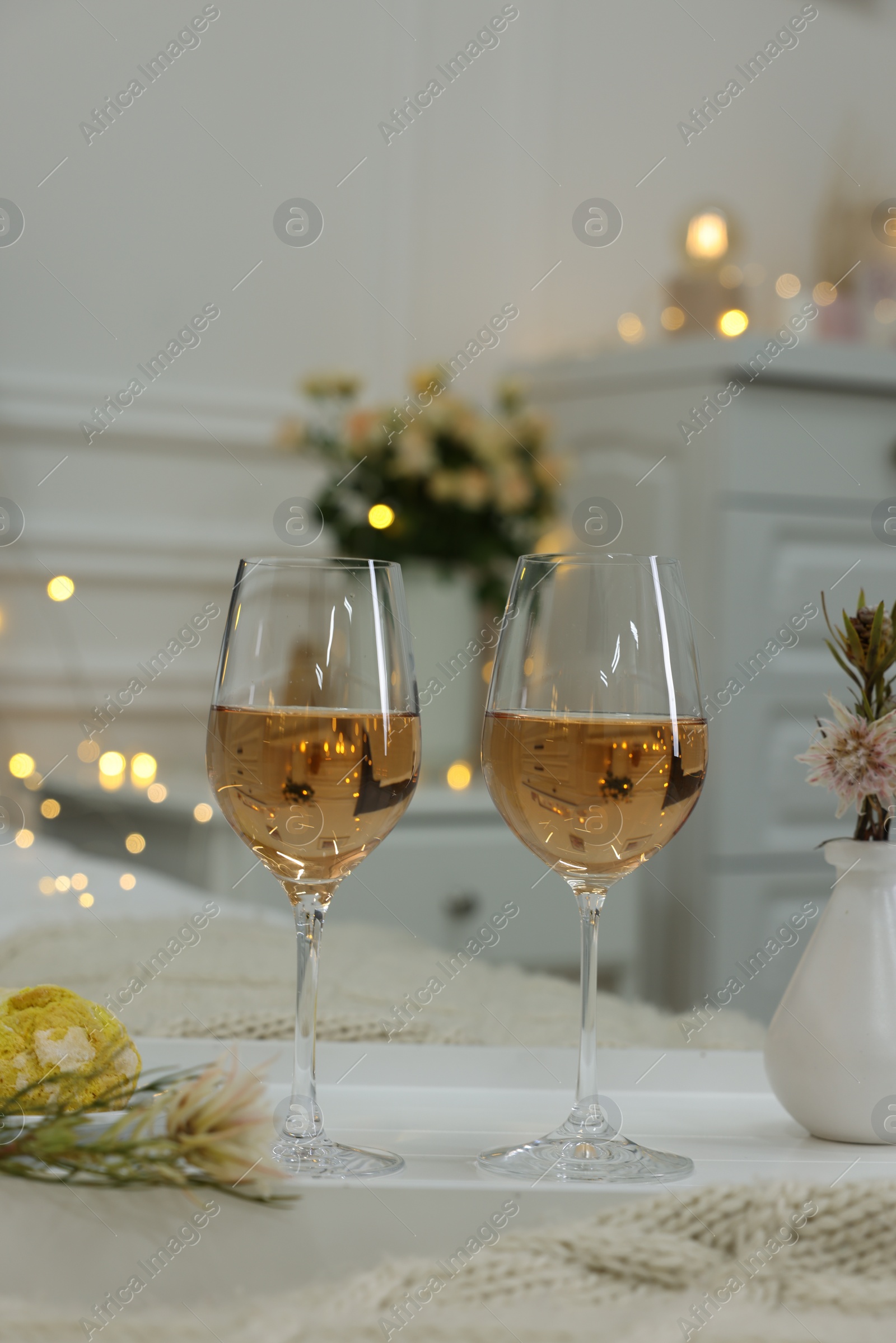 Photo of Tray with glasses of wine in bedroom adorned for romantic date