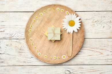 Composition with chamomile flowers on white wooden table, top view