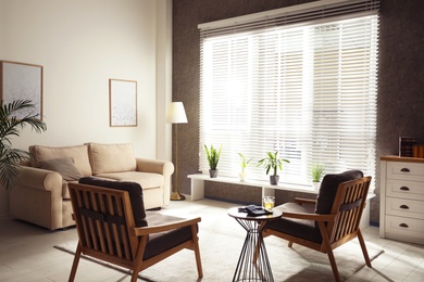 Living room interior with comfortable sofa and armchairs