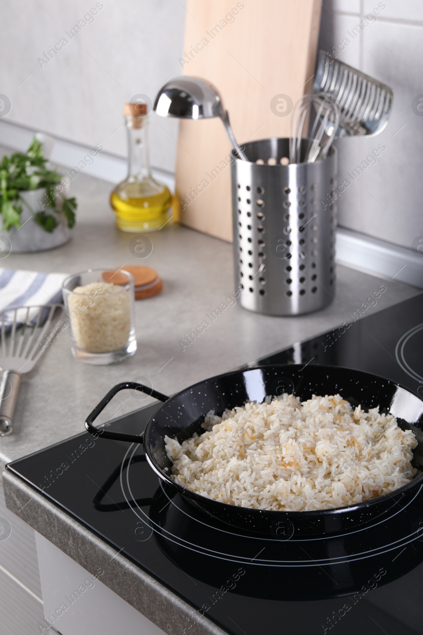 Photo of Cooking tasty rice on induction stove in kitchen
