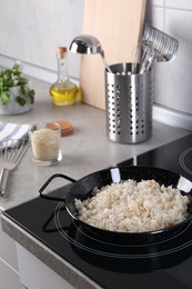 Cooking tasty rice on induction stove in kitchen