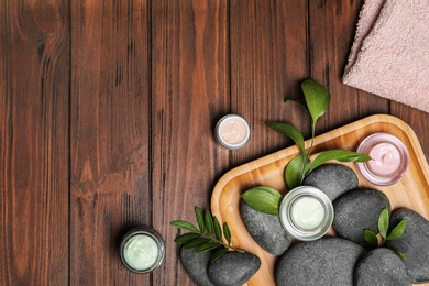 Flat lay composition with spa stones and space for text on wooden background