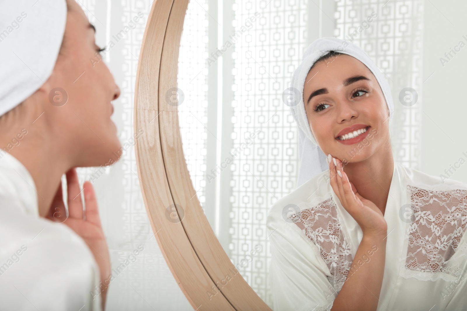 Photo of Beautiful young woman with perfect skin near mirror in bathroom. Facial wash