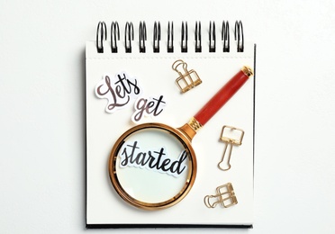 Photo of Sheets of paper with phrase Let's Get Started, stationery and magnifying glass on white table, top view