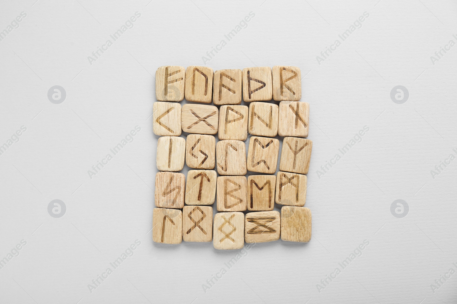 Photo of Wooden runes on white background, top view