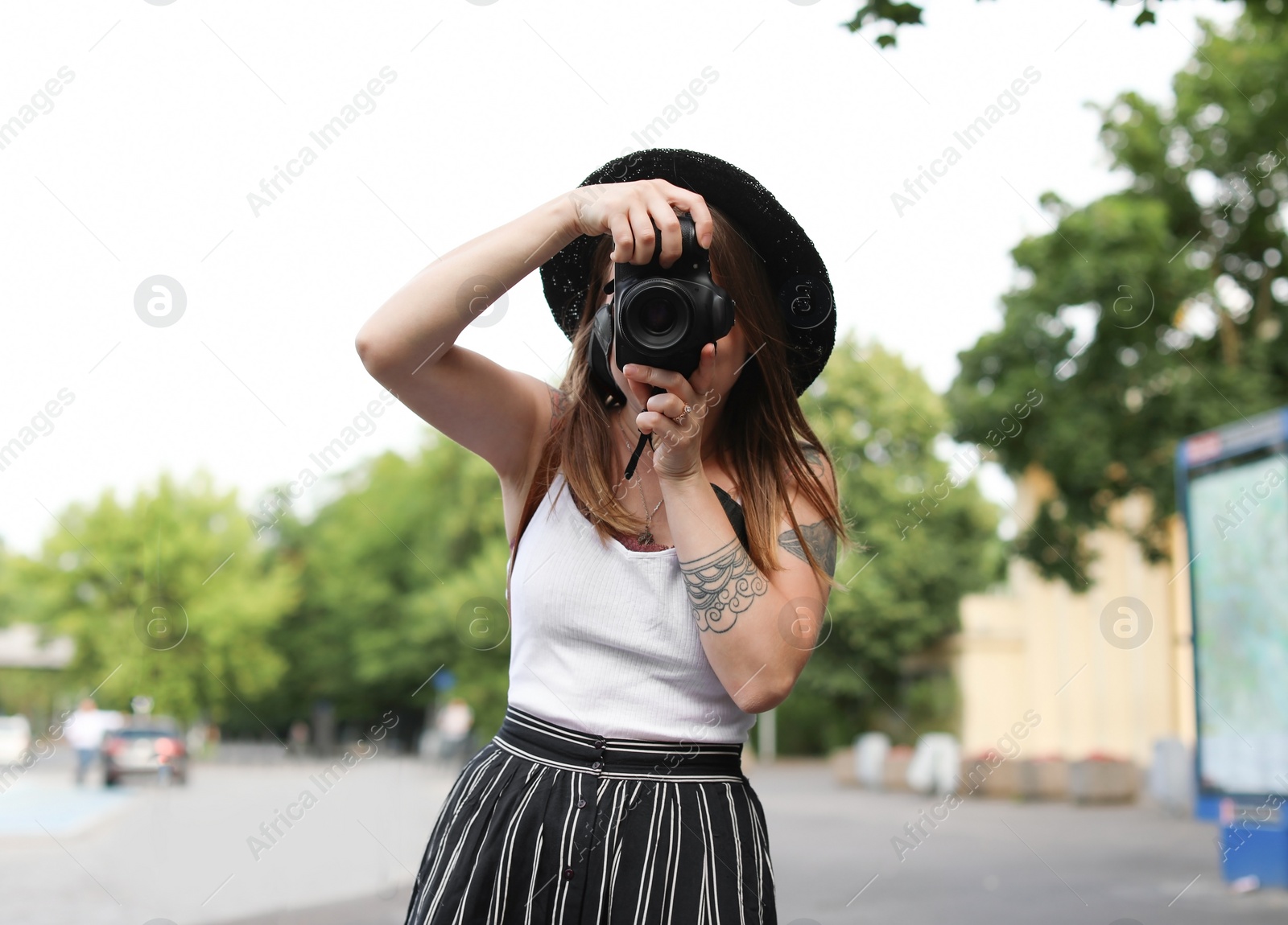 Photo of Young photographer with camera on city street