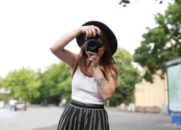 Photo of Young photographer with camera on city street