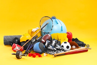 Many different sports equipment on yellow background