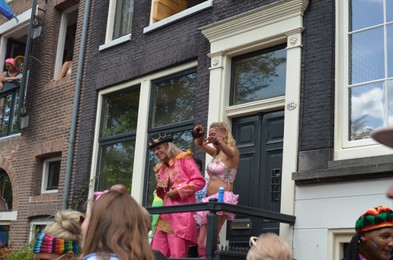 AMSTERDAM, NETHERLANDS - AUGUST 06, 2022: People near building at LGBT pride parade on sunny day