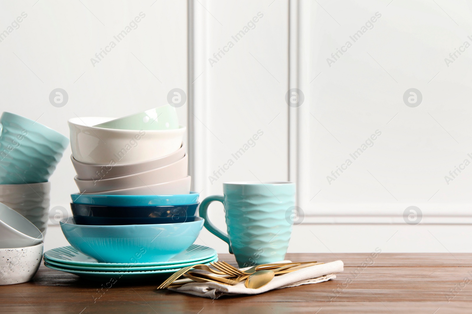 Photo of Beautiful ceramic dishware, cup and cutlery on wooden table, space for text