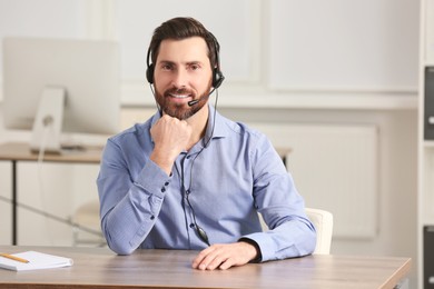 Hotline operator with headset working in office