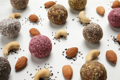 Delicious vegan candy balls and nuts on white table
