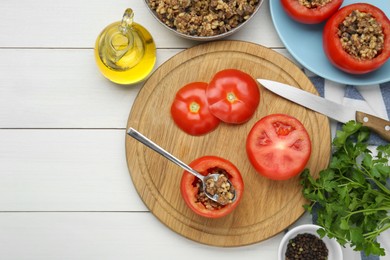 Preparing stuffed tomatoes with minced beef, bulgur and mushrooms on white wooden table, flat lay. Space for text