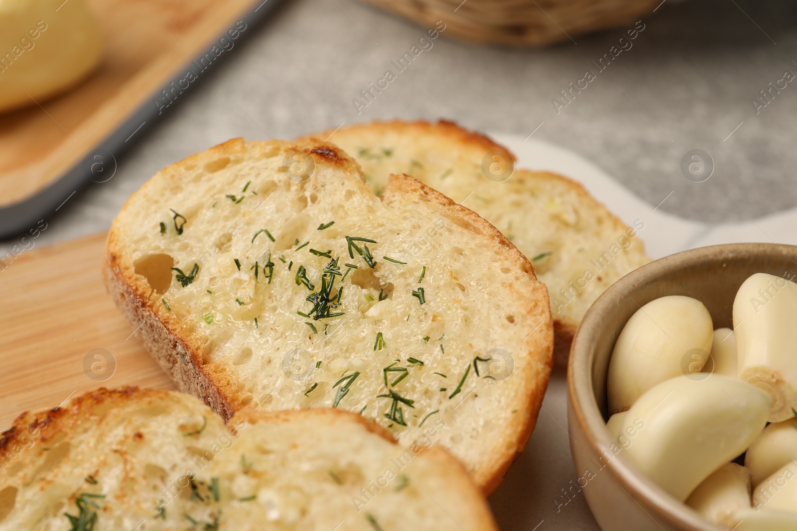 Photo of Tasty baguette with garlic and dill on table, closeup