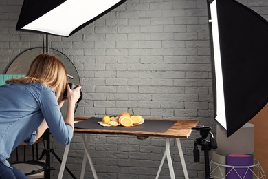Photo of Woman taking photo of food with professional camera in studio