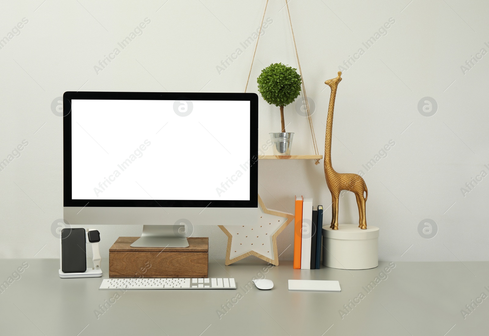 Photo of Modern workplace with computer, charging devices and decor elements. Interior design