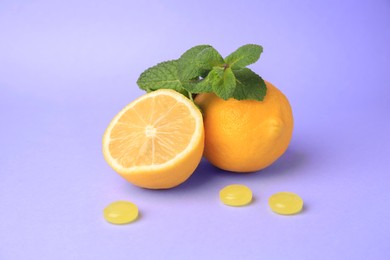 Photo of Fresh lemons, mint leaves and cough drops on lilac background