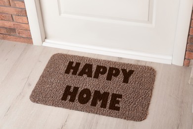 Image of Door mat with words Happy Home on wooden floor in hall, above view