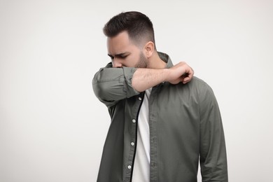 Photo of Sick man coughing on white background, space for text