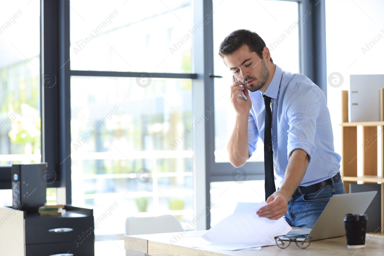 Photo of Male business trainer talking on phone in office