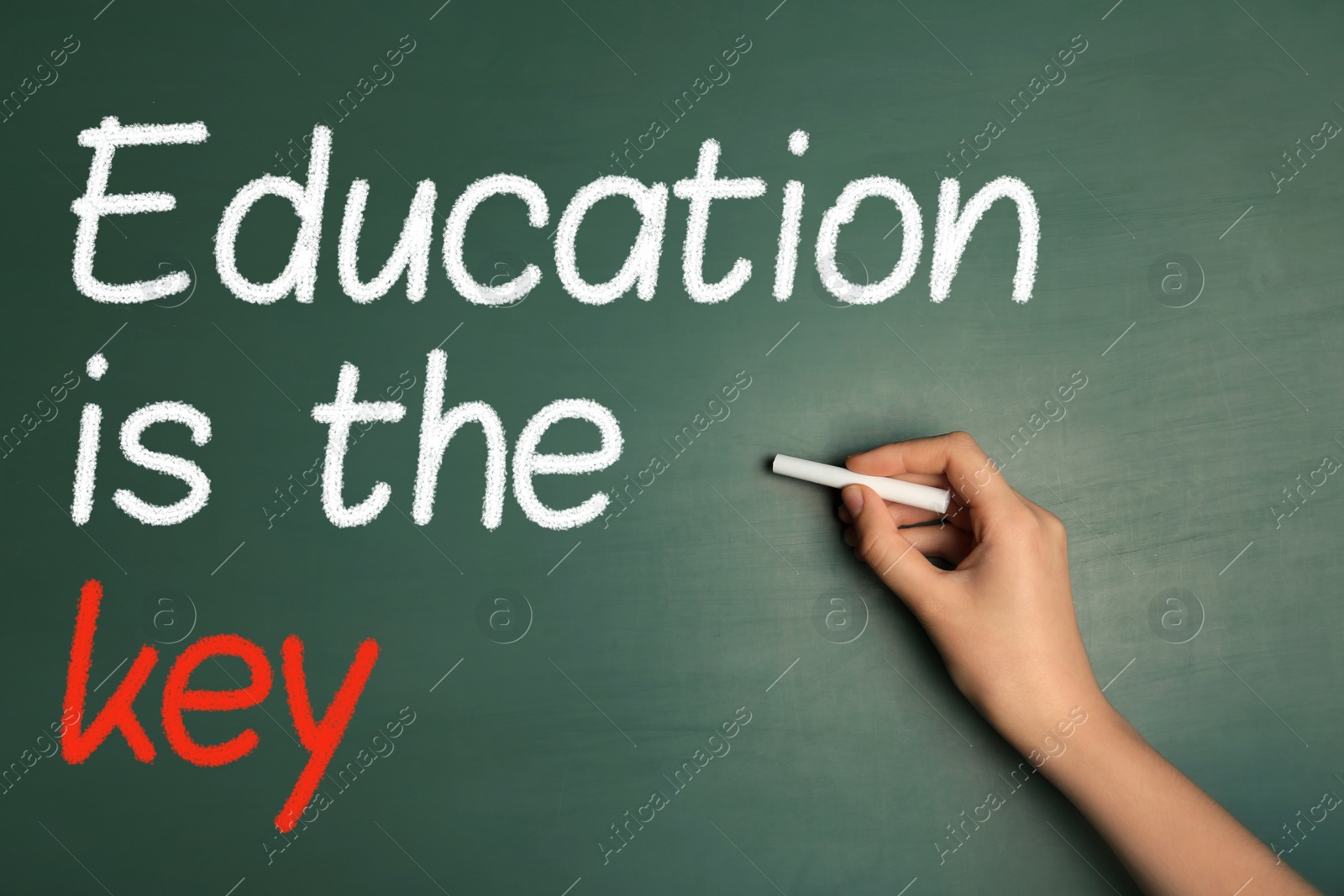 Image of Woman writing phrase Education is the key on chalkboard, closeup. Adult learning