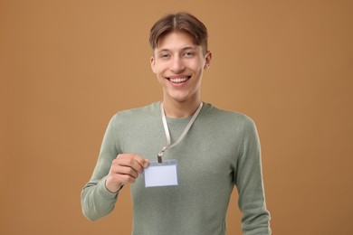 Photo of Happy man with blank badge on light brown background