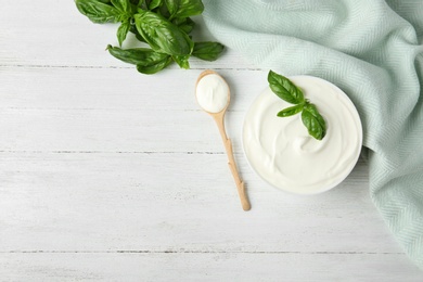 Photo of Flat lay composition with sour cream and basil on white wooden table. Space for text