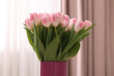 Beautiful bouquet of fresh pink tulips indoors