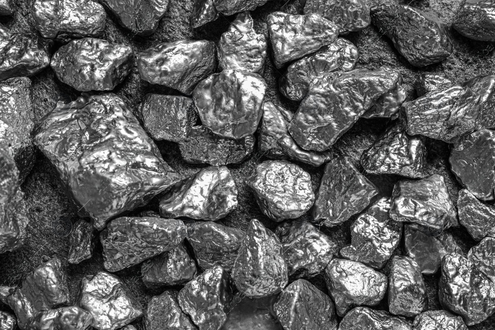 Photo of Many silver nuggets on grey textured table, top view