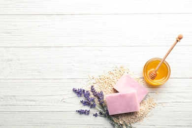 Photo of Flat lay composition with handmade soap bars and space for text on wooden background