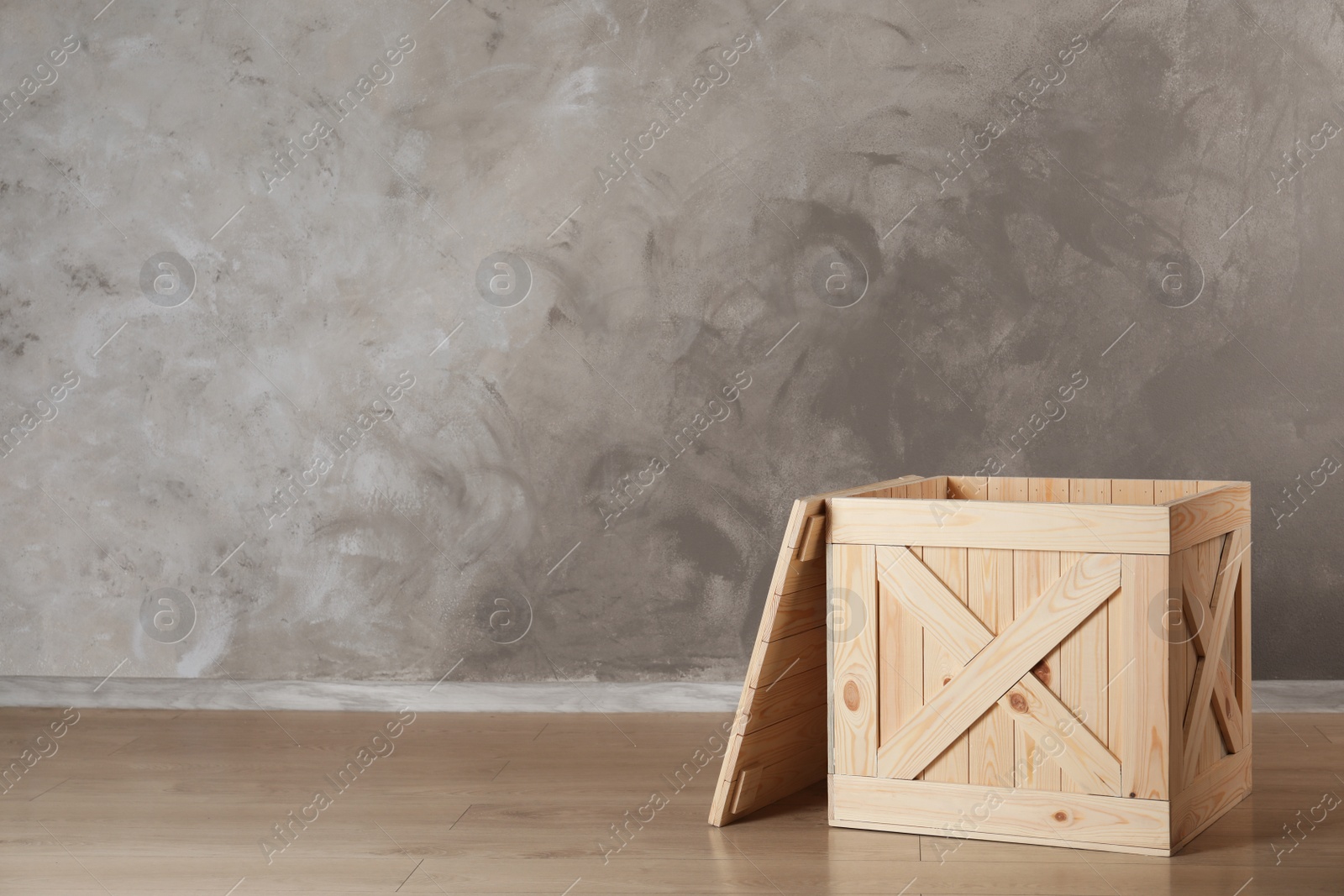 Photo of Wooden crate on floor against color background, space for text