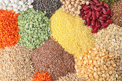 Different types of legumes and cereals as background, top view. Organic grains