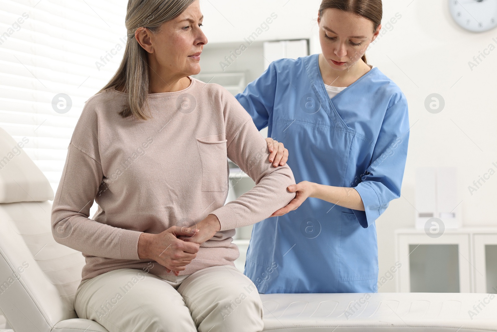 Photo of Arthritis symptoms. Doctor examining patient's elbow in hospital