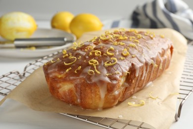 Photo of Tasty lemon cake with glaze on white table, closeup