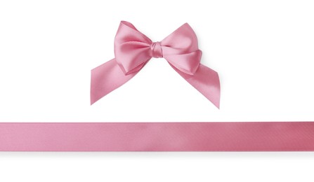 Pink satin ribbon and bow on white background, top view