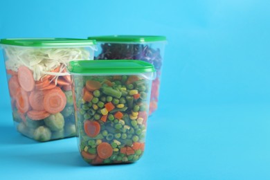 Photo of Set of plastic containers with fresh food on light blue background, space for text