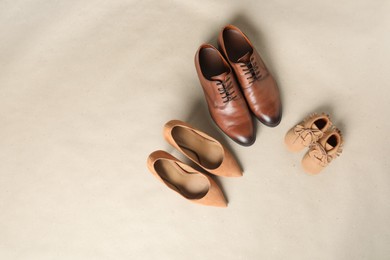 Photo of Mother's, father's and child's shoes on beige background, flat lay with space for text. Family day