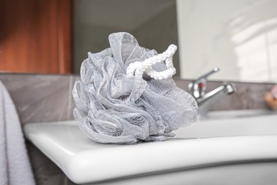 Grey shower puff on washbasin in bathroom, closeup