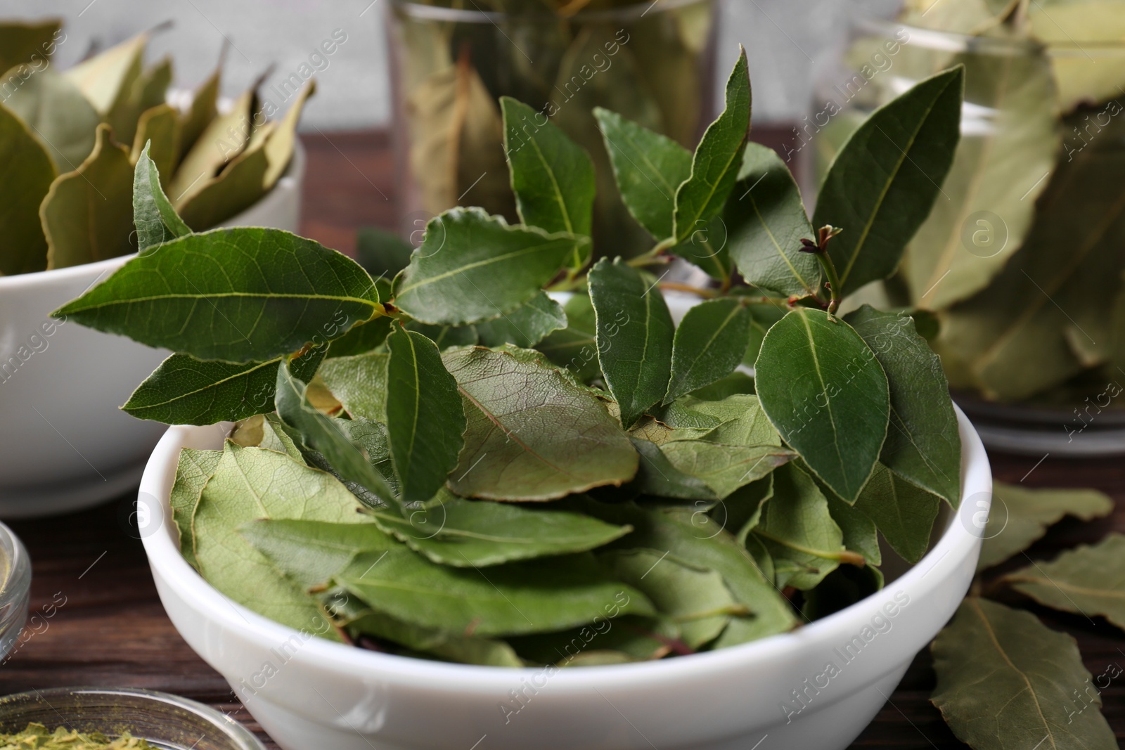 Photo of Fresh and dry bay leaves on wooden table, closeup