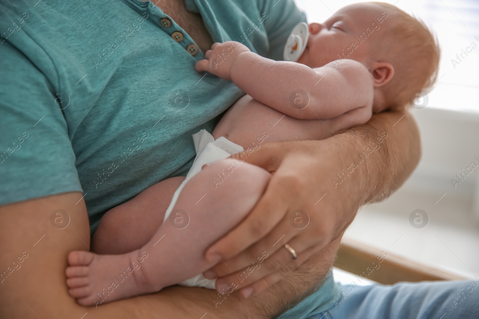 Photo of Father with his newborn son, closeup view