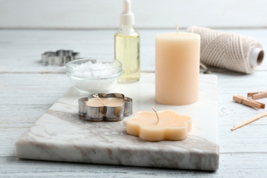 Photo of Handmade candles with cutter on wooden background