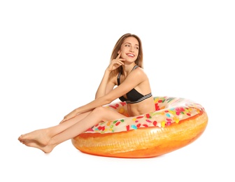 Photo of Beautiful young woman in stylish bikini with doughnut inflatable ring on white background