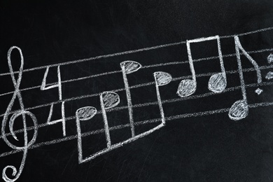 Photo of Music staff with treble clef and notes written on chalkboard