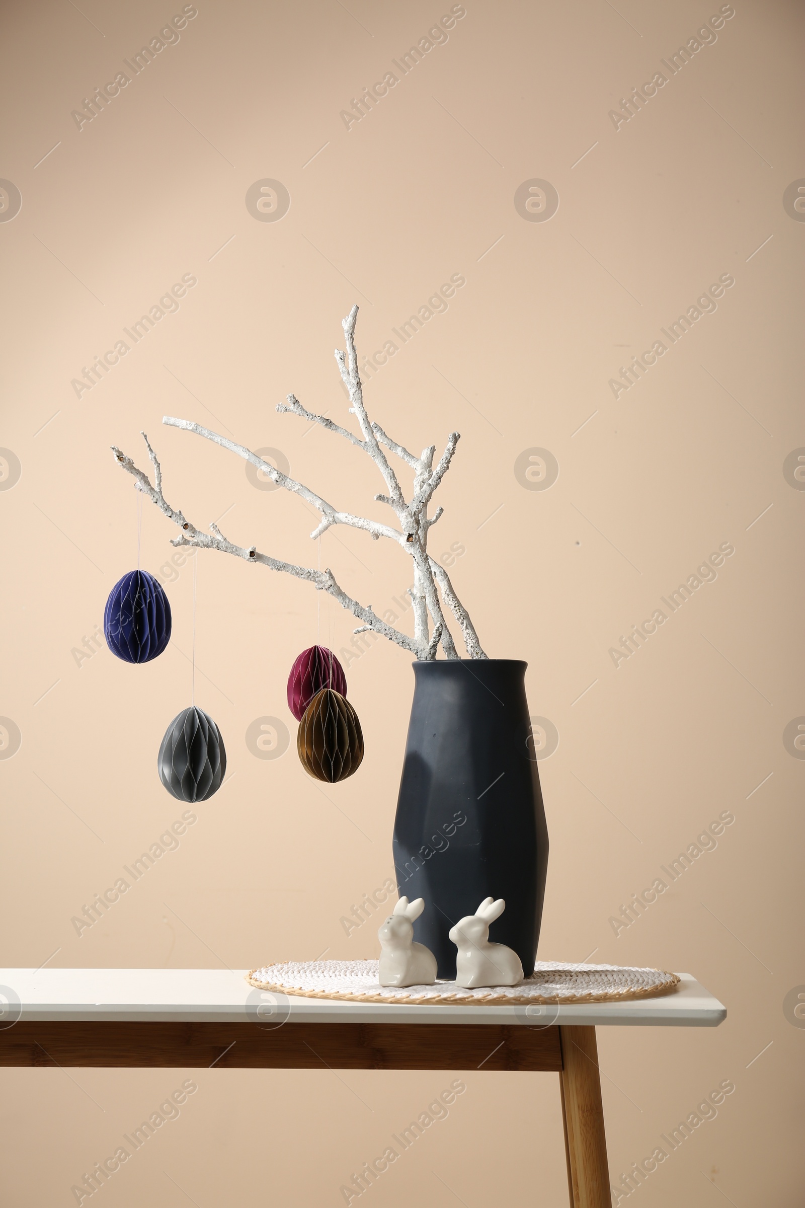 Photo of Beautiful festive composition with Easter decor on white table against beige background