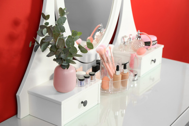 Dressing table with mirror and makeup products, closeup