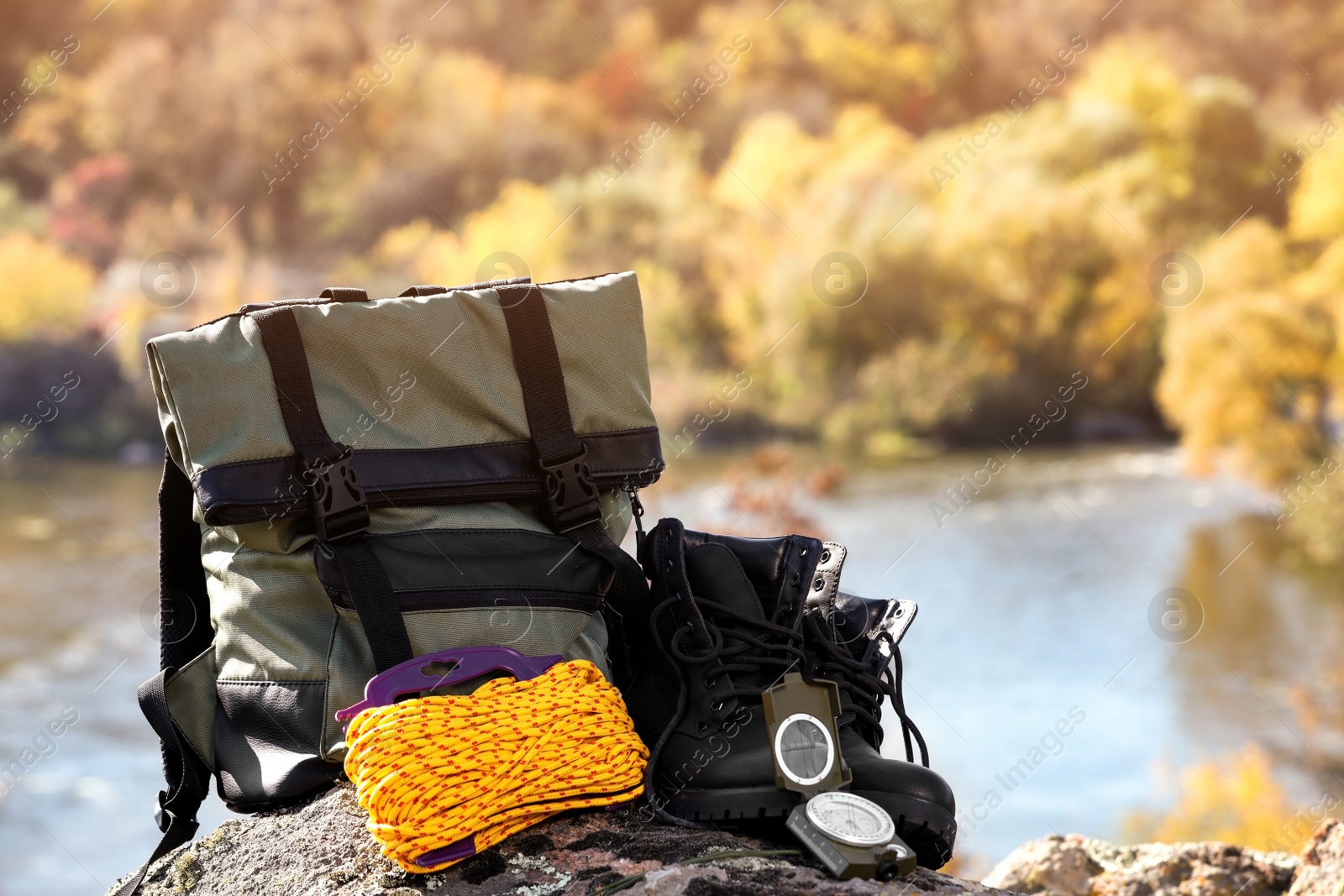 Photo of Set of camping equipment on rock outdoors. Space for text