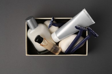 Photo of Box with different men's shaving accessories on dark grey background, top view