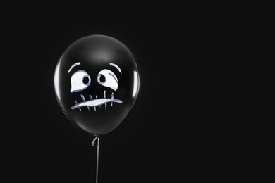 Photo of Spooky balloon for Halloween party on black background, space for text